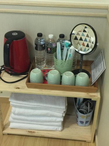 a shelf with towels and cups and a mirror at Summerle No.11 in Chaozhou