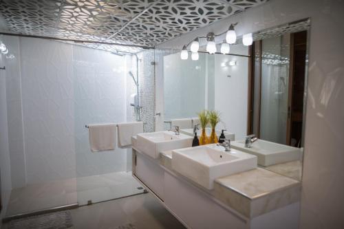 a white bathroom with two sinks and a mirror at Pratumnak Soi 5 Bungalow 3 in Pattaya South