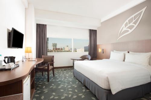 a hotel room with a bed and a desk at Swiss-Belinn Kemayoran in Jakarta