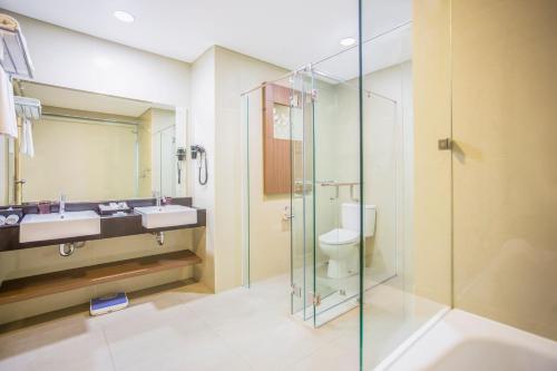 y baño con ducha de cristal y aseo. en Swiss-Belinn Kemayoran, en Yakarta