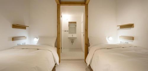a hotel room with two beds and two lamps at Norden Ruder Hostel Taichung in Taichung