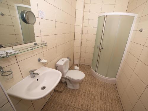 a bathroom with a toilet and a sink and a shower at Deims Hotel in Šilutė