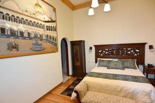 a bedroom with a bed and a picture of a building at Hotel La Basílica Quito in Quito