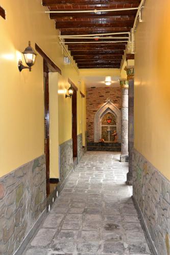 an empty hallway of a building with a brick wall at Hotel La Basílica Quito in Quito