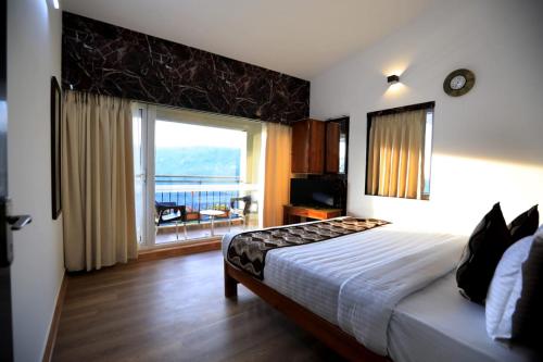 1 dormitorio con cama y ventana grande en Cherry Blossom Homestay en Kodaikānāl