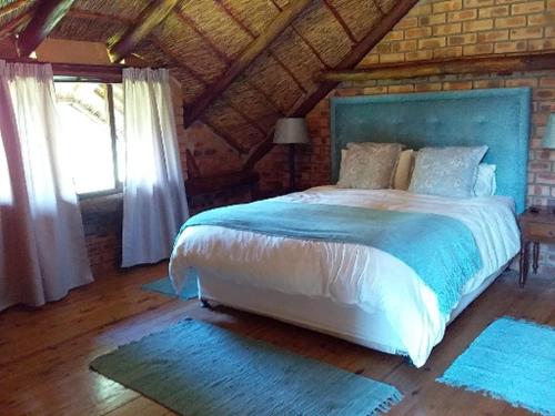 a bedroom with a large bed with a blue headboard at Crocriver Chalet Schoemanskloof in Schoemanskloof