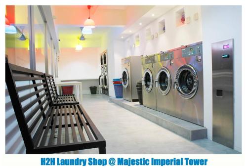 a laundry room with two washing machines and a bench at H2H - Eleven14 Majestic Ipoh in Ipoh