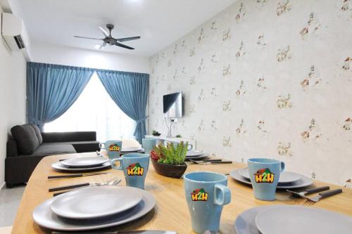 a dining room with a table with plates and utensils at H2H - Eleven14 Majestic Ipoh in Ipoh