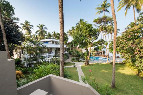 una vista dal balcone di un resort con palme di O Pescador an Indy Resort a Panaji