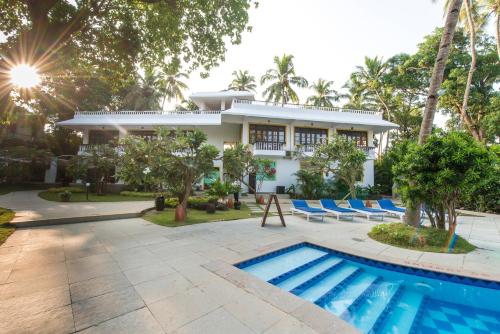 uma villa com piscina e um resort em O Pescador an Indy Resort em Panaji