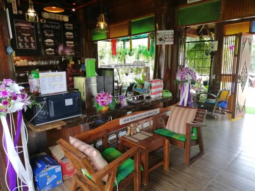 una tienda con un mostrador con sillas y flores en Heanmaeloung Resort., en Chiang Mai