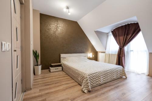 a bedroom with a bed and a large window at Apartment Doyran in Ruse