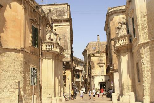 a group of people walking down a street between two buildings at Lo Scacciapensieri Hotel & Restaurant in Monteroni di Lecce