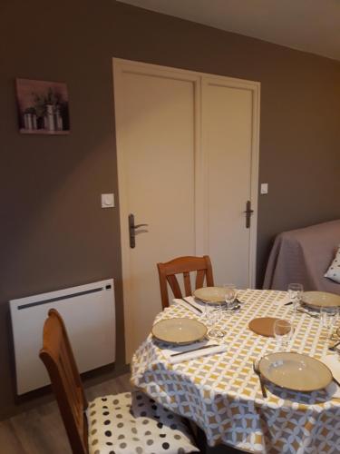 einen Tisch mit Tellern auf einem Zimmer in der Unterkunft Chalet "Les Gobelins" in Paimpont