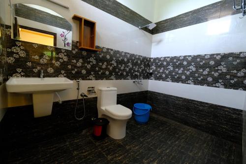 a bathroom with a sink and a toilet at Marari Arapakal Beach Villa in Mararikulam