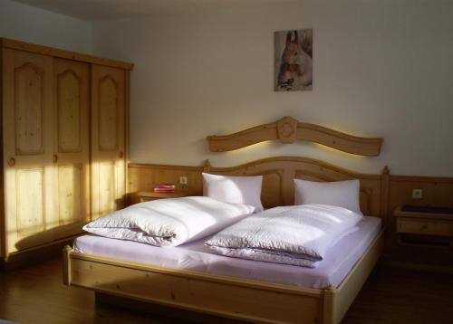 een slaapkamer met 2 bedden en witte kussens bij Ferienhaus Hirterhütte in Abtenau