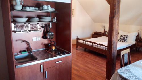 a kitchen with a sink and a bed in a room at Apartments U Kašny in Kadaň