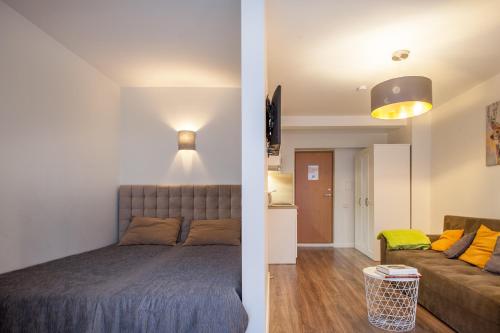 ein Schlafzimmer und ein Wohnzimmer mit einem Bett und einem Sofa in der Unterkunft Dubingių apartamentai Nr. 2 in Vilnius