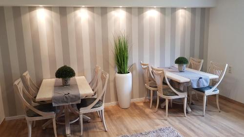 Pension Gockels-Auszeit في باد فيلدونجين: غرفة طعام مع طاولتين وكراسي ونباتات