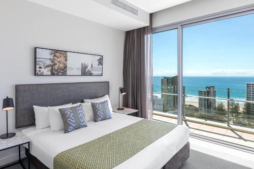 a bedroom with a bed and a large window at Wyndham Resort Surfers Paradise in Gold Coast
