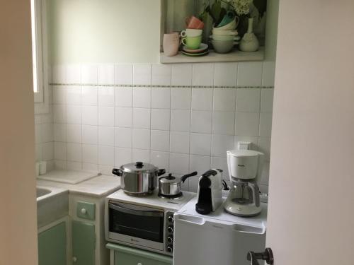 a kitchen with a stove with pots and pans on it at Athens-Plaka, Peter’s beautiful apartment in Temple of Zeus in Athens