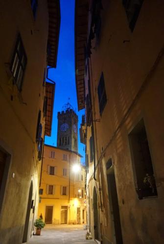 a clock tower in the middle of a street at night at Casa Vicolo delle Chiavi in Poggibonsi
