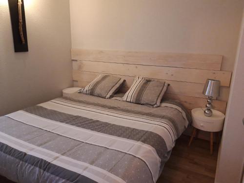 a bedroom with a bed with a wooden headboard at Appartandernos in Andernos-les-Bains