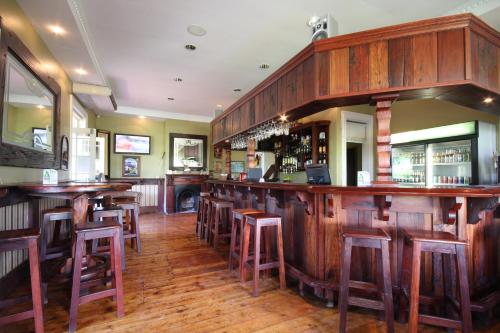 um bar com bancos de madeira num restaurante em Katberg Eco Golf Estate em Balfour