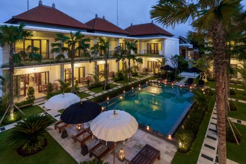 an aerial view of a house with a pool and umbrellas at Puri Uma Ratu by RPM in Seminyak