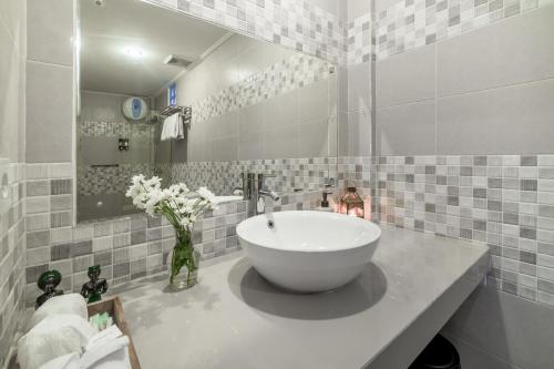 a bathroom with a large white bowl sink in it at Puri Uma Ratu by RPM in Seminyak