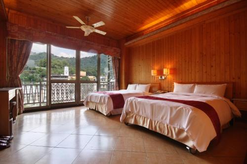 2 camas en un dormitorio con balcón en Ku Kuan Resort Hotel en Heping