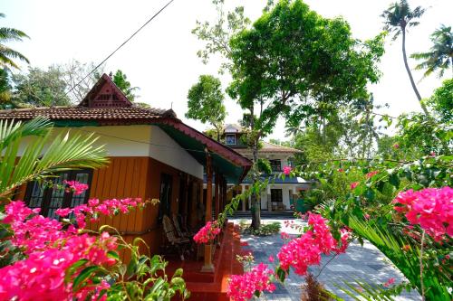 a house with pink flowers in front of it at Marari Arapakal Beach Villa in Mararikulam