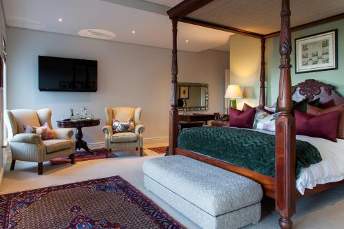 a bedroom with a canopy bed and a living room at Tintswalo Boulders in Simonʼs Town