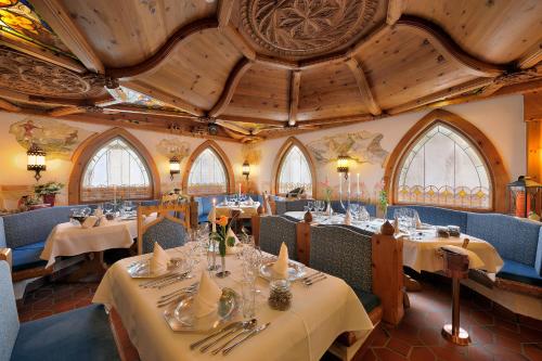 索爾登的住宿－多米尼克酒店，餐厅设有桌椅和格子天花板