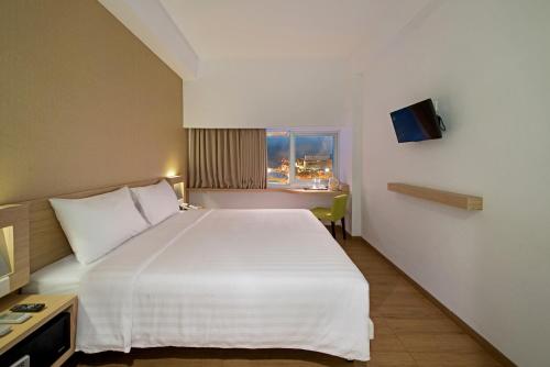 เตียงในห้องที่ Whiz Prime Hotel Megamas Manado