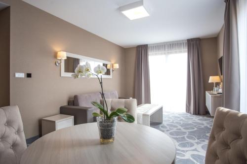 a room with a table and a living room at Hotel Rondo in Wąbrzeźno