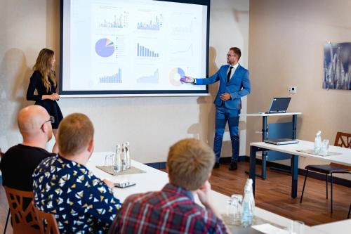 a man giving a presentation in front of a group of people at Hotel Rondo in Wąbrzeźno