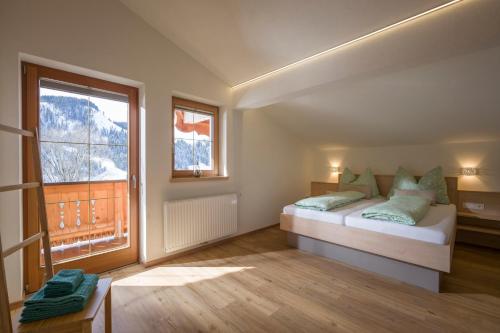 - une chambre avec un lit et une grande fenêtre dans l'établissement Jodlhof, à Söll