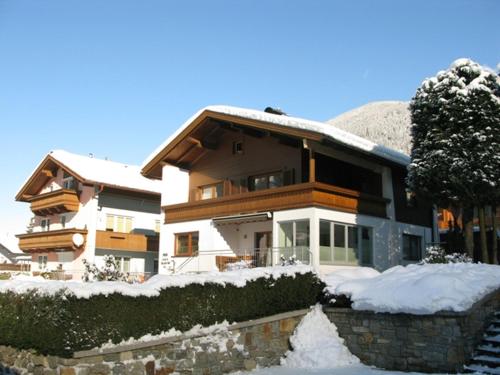 a house with snow on the ground in front of it at Haus Dejakom Mayrhofen in Mayrhofen