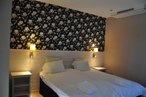 a bedroom with a bed with a black and white wallpaper at Hotel Bella Luna in Båstad