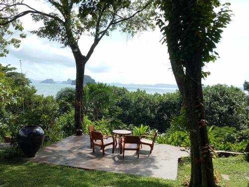 a table and chairs sitting on a patio with a view of the ocean at Le Passe-Temps in Tha Lane Bay