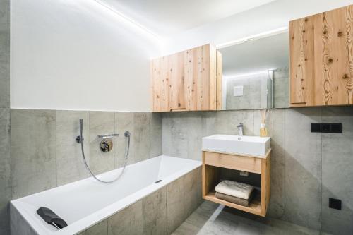 a bathroom with a tub and a sink and a shower at Lüch de Costa in Colfosco