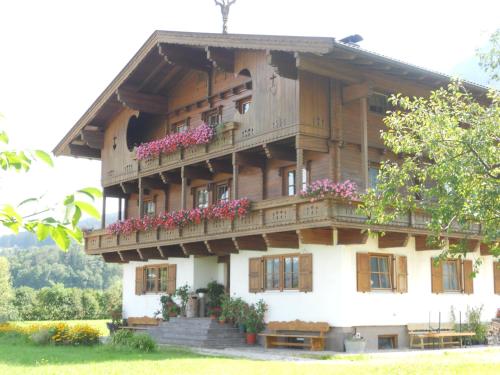 a large wooden building with flowers on the balconies at Neuschwendterhof in Ebbs