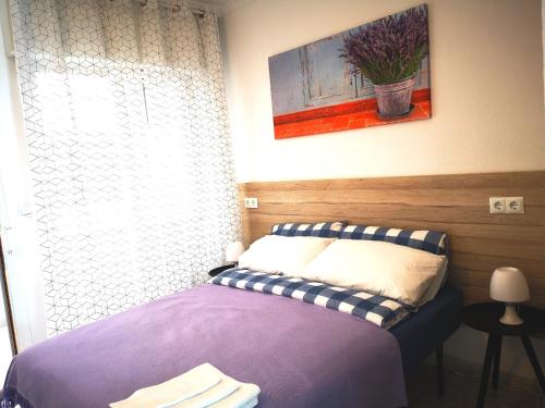 een slaapkamer met een paars bed en een schilderij aan de muur bij Apartment Granada 302 Pool&Beach in Torrevieja