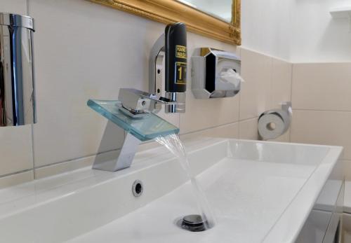 a bathroom sink with water coming out of a faucet at Hotel Zehnthof in Cochem