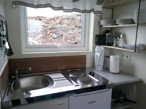 een keuken met een wastafel en een raam bij Vatnsás 10 in Stykkishólmur