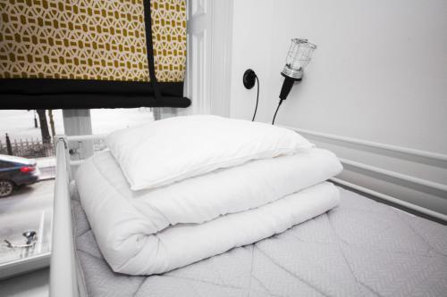 a stack of pillows on a bed in a room at City Backpackers Hostel in Stockholm