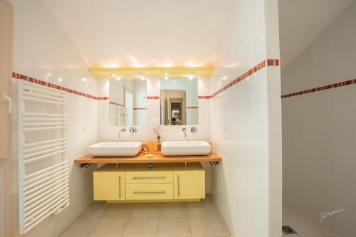 a bathroom with two sinks and a mirror at Chalet BIRON - Piscine & Tennis - Gîtes de Poubille in Blanquefort-sur-Briolance