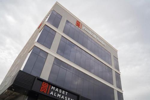 a tall building with a sign in front of it at Maset Al Masem Apartments Units in Al Khobar
