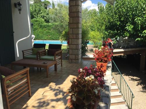 - une terrasse avec une table, des chaises et des fleurs dans l'établissement La Pichioline, à Alès